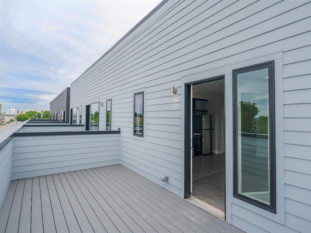 a balcony with a door and a white house