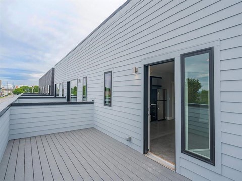 a balcony with a door and a white house