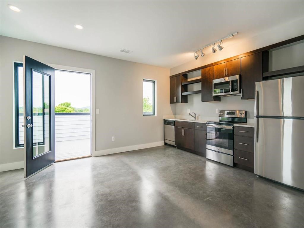 a kitchen with stainless steel appliances and a door to a patio