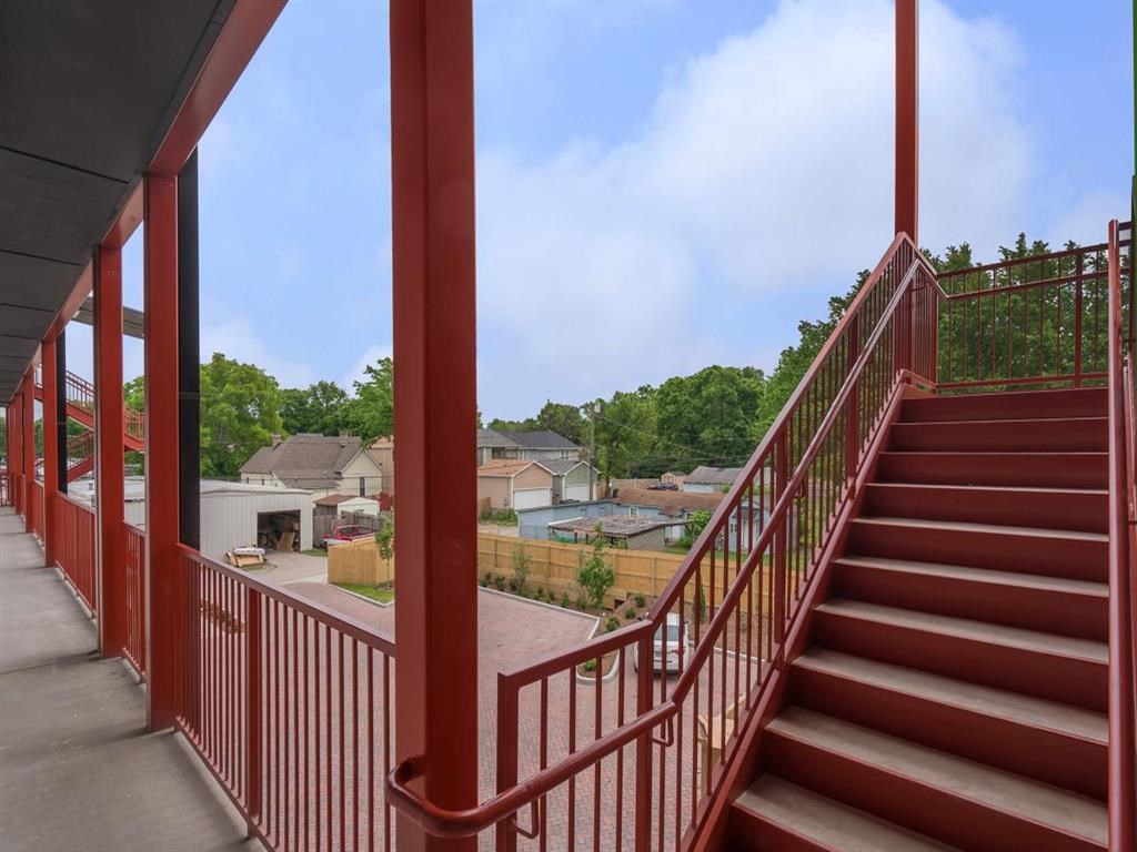 a view of a city from a balcony with red stairs