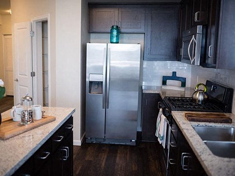 a kitchen with a stainless steel refrigerator and a sink