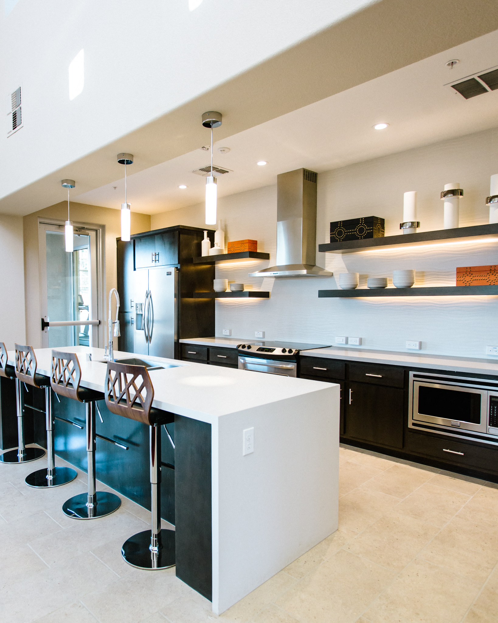 A modern kitchen with black cabinets and a white island.