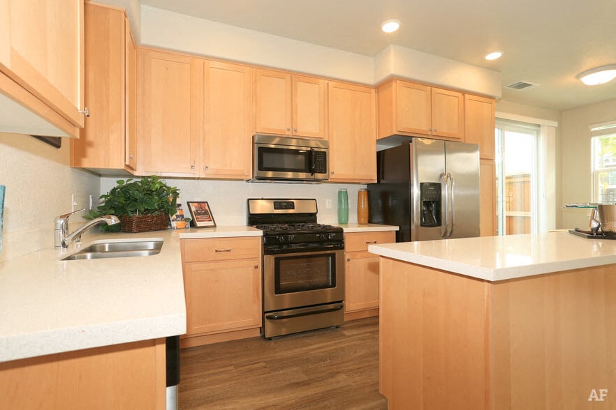 A kitchen with wooden cabinets and a white countertop.