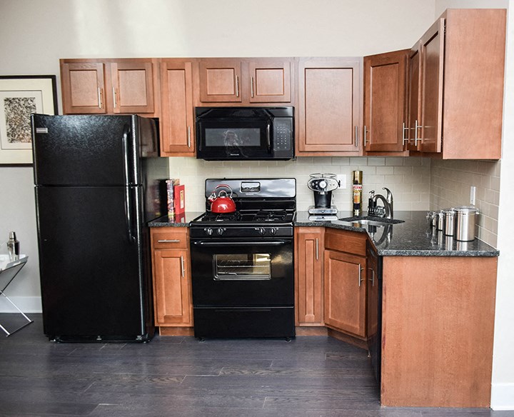 a kitchen with black appliances and wooden cabinets
