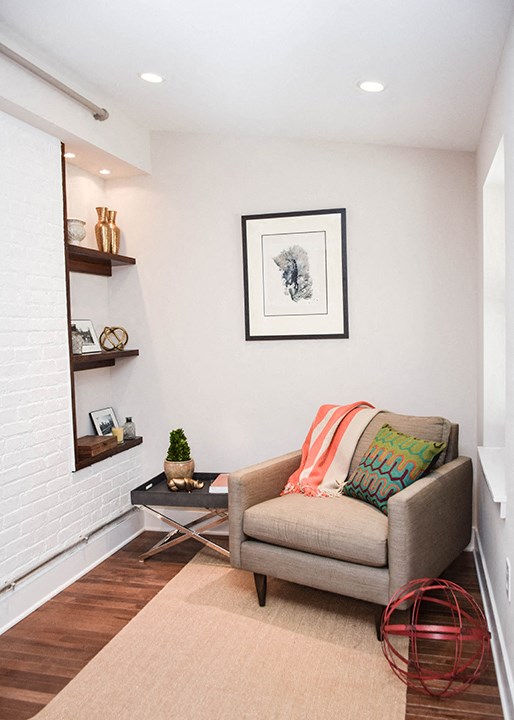 a small living room with a chair and a fireplace