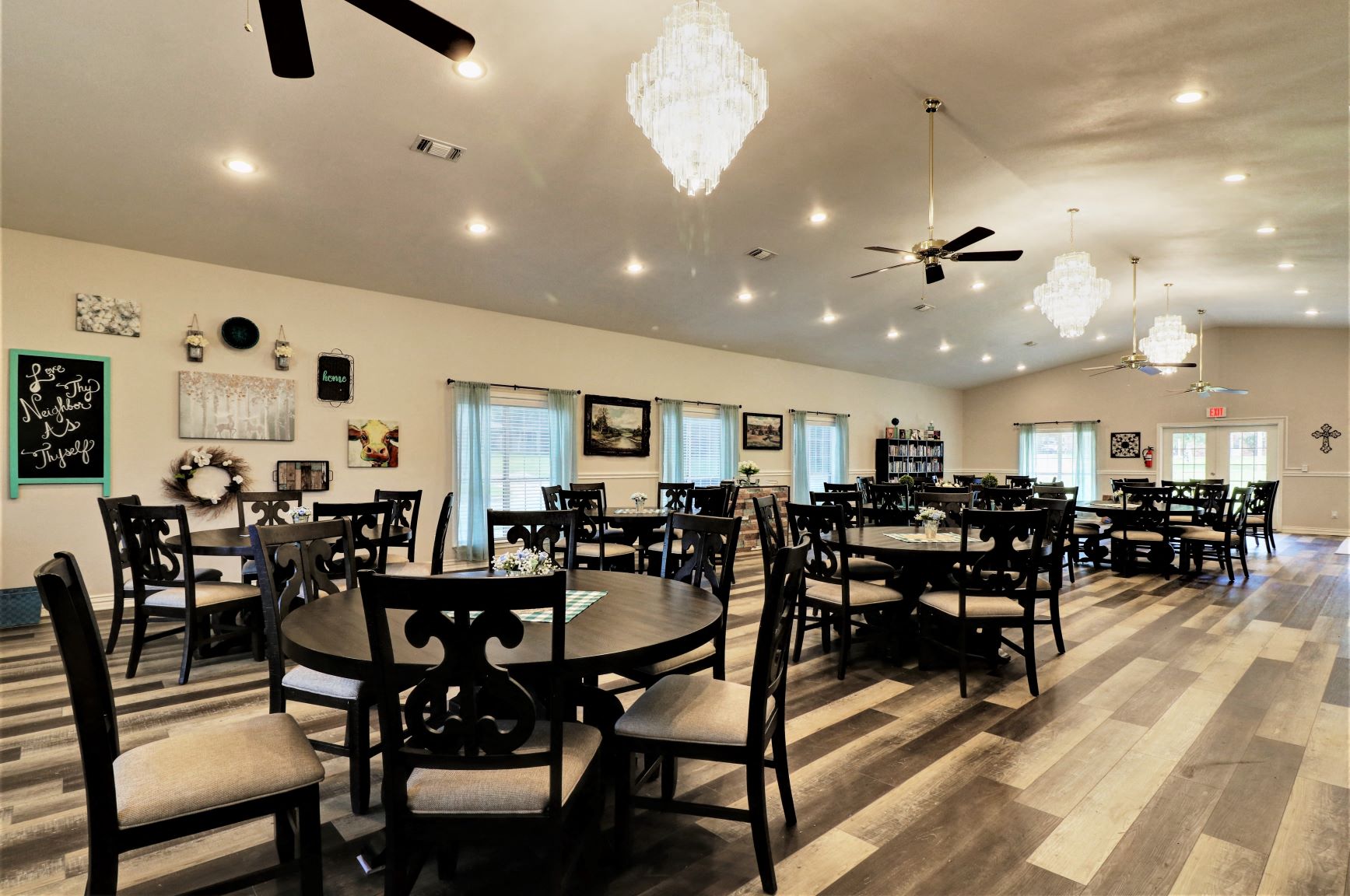 a dining room with tables and chairs and chandeliers