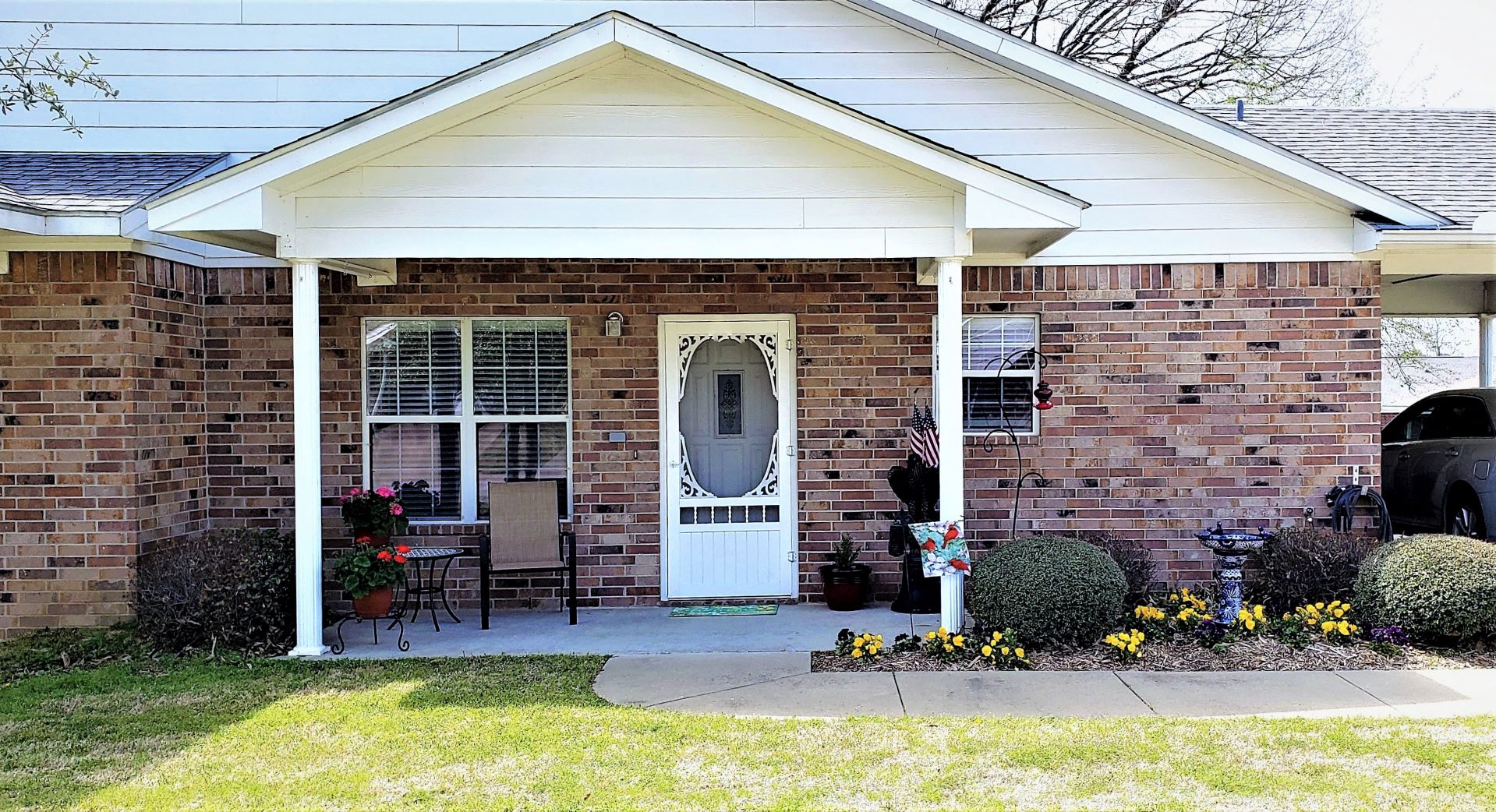 a front porch of a brick house with a white door
