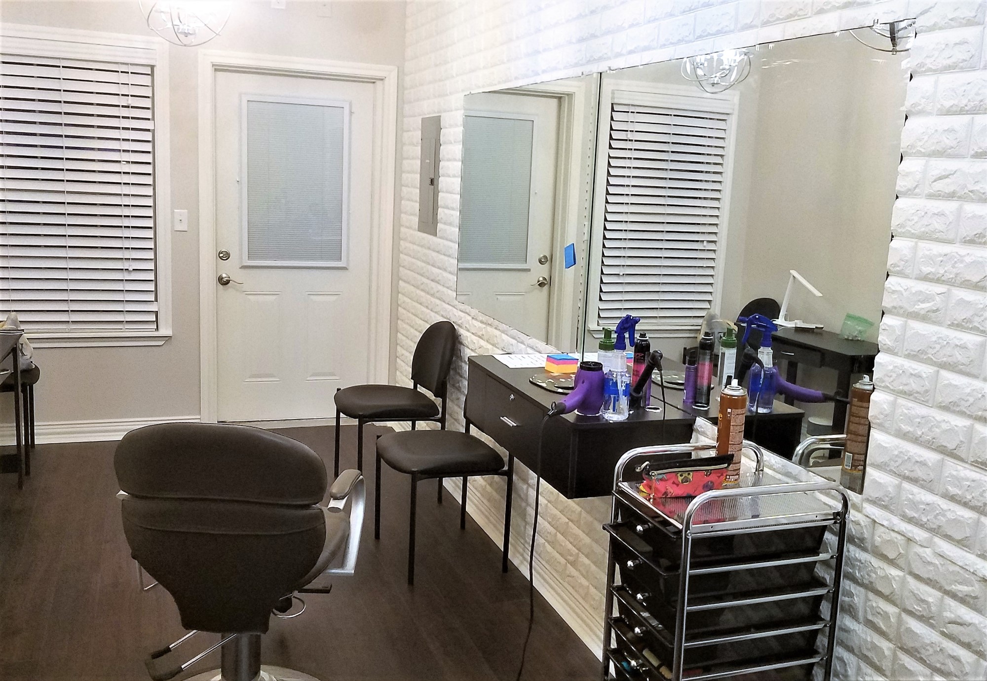 a salon room with a vanity and chairs and a mirror
