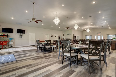 a large dining room with tables and chairs and ceiling fans
