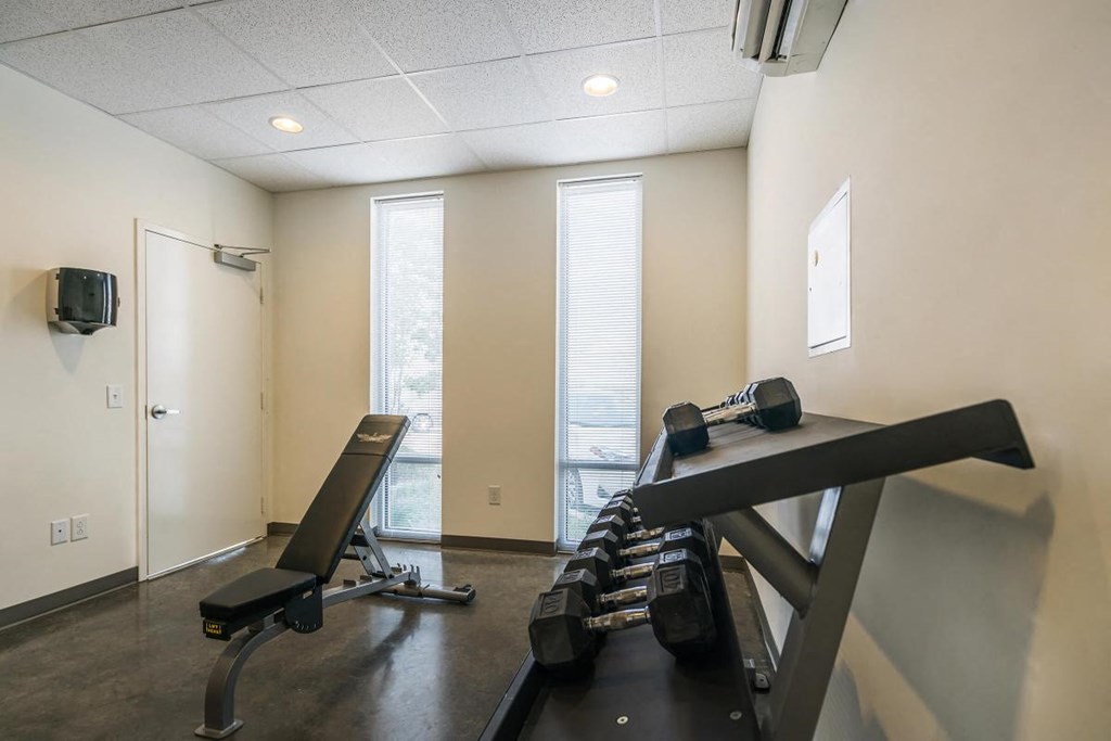 a workout room with a treadmill and a tv