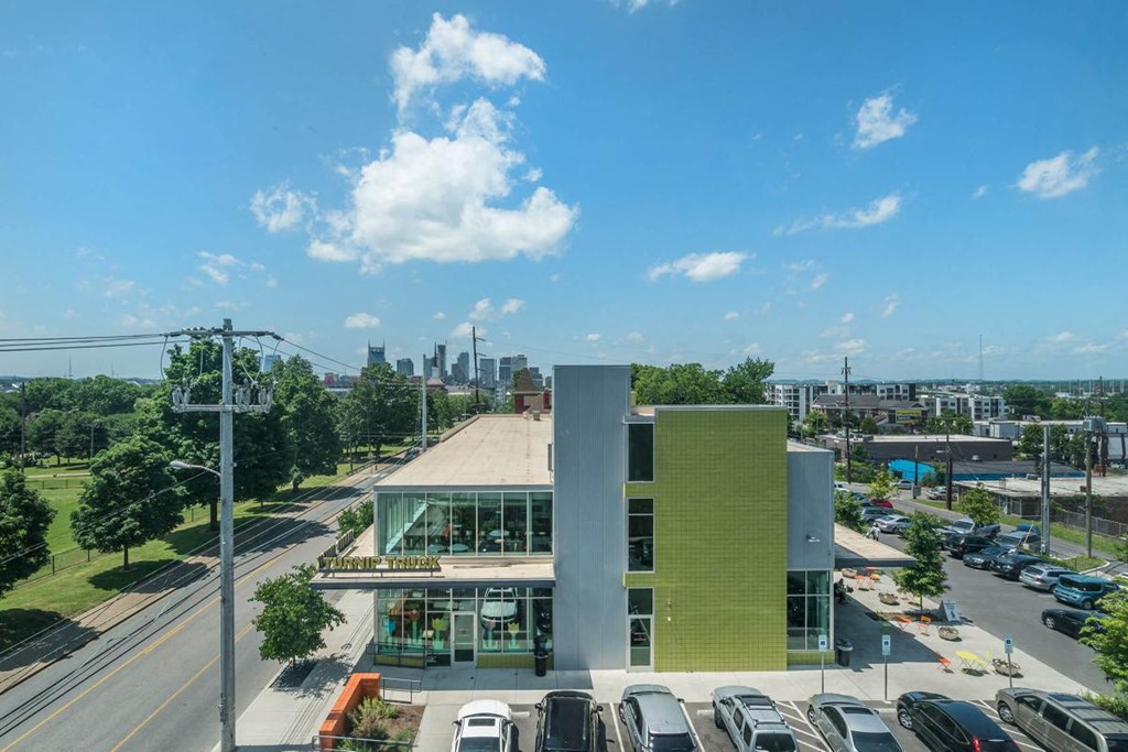 a building with a parking lot and a city in the background