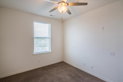 a bedroom with a ceiling fan and a window