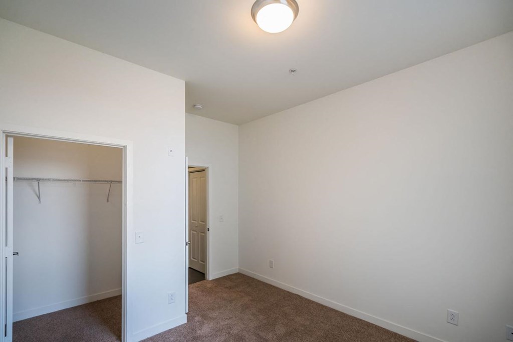 a bedroom with white walls and a closet