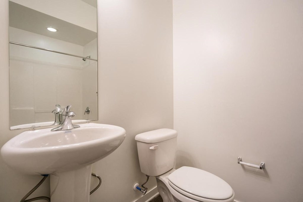 a bathroom with a sink toilet and a mirror