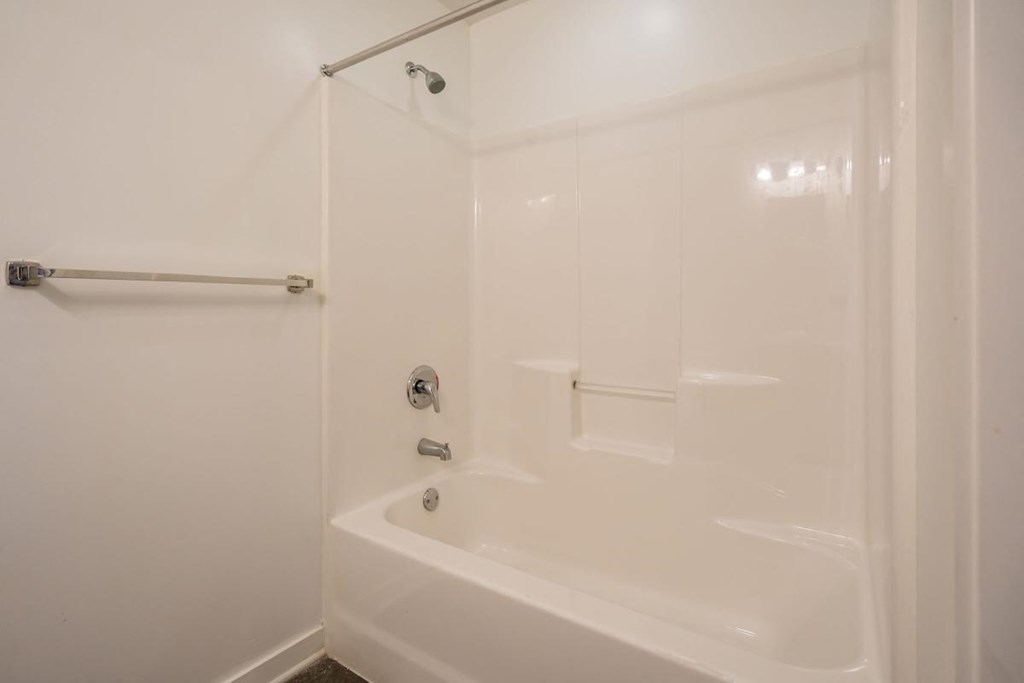a white bathroom with a shower and a tub