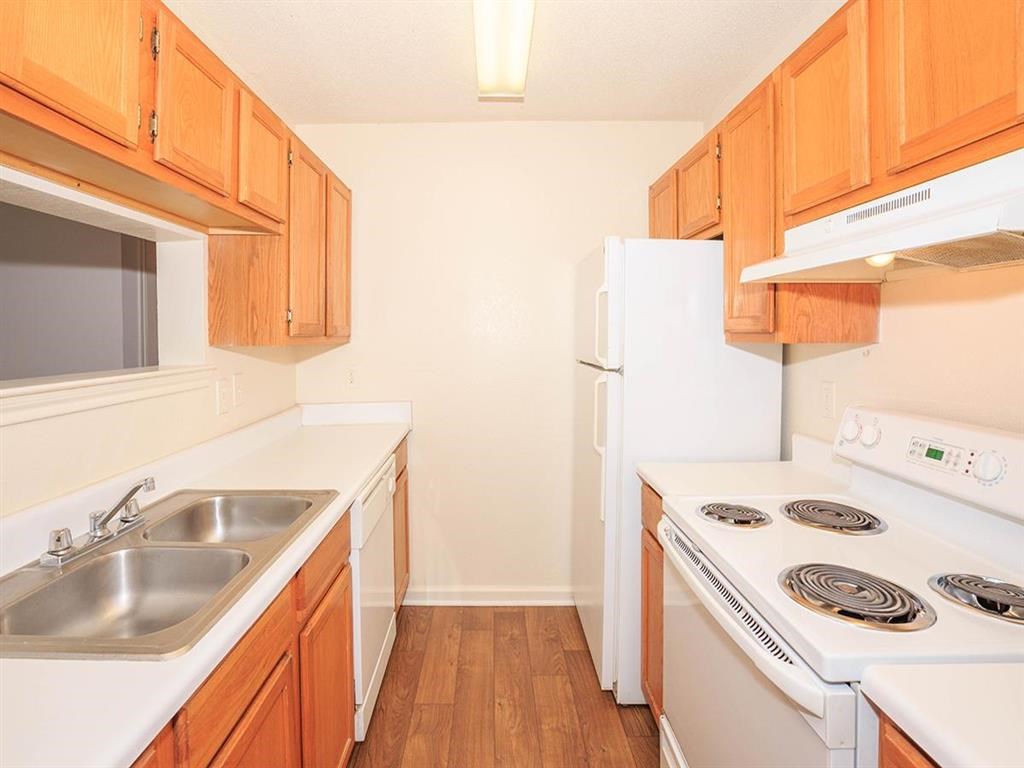 a kitchen with white appliances and wooden cabinets