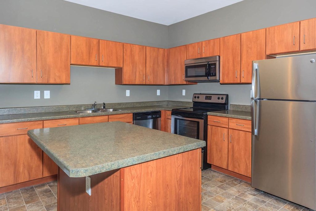 a kitchen with stainless steel appliances and wooden cabinets