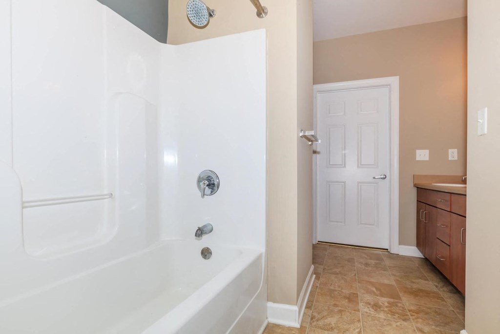 a bathroom with a tub and a sink and a door