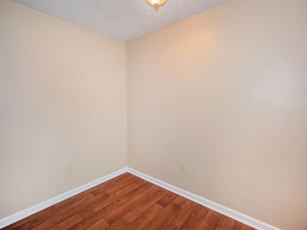 an empty room with wood flooring and white walls
