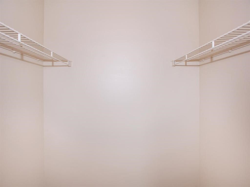 an empty room with a white wall and two white shelves