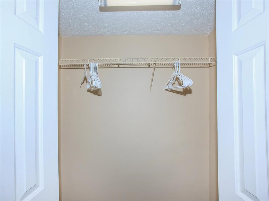 a closet with two hooks and a clothes rack