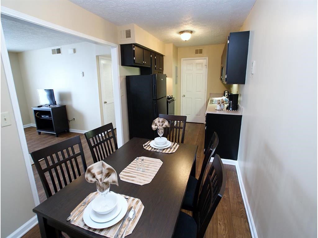 a dining room and kitchen with a table and chairs
