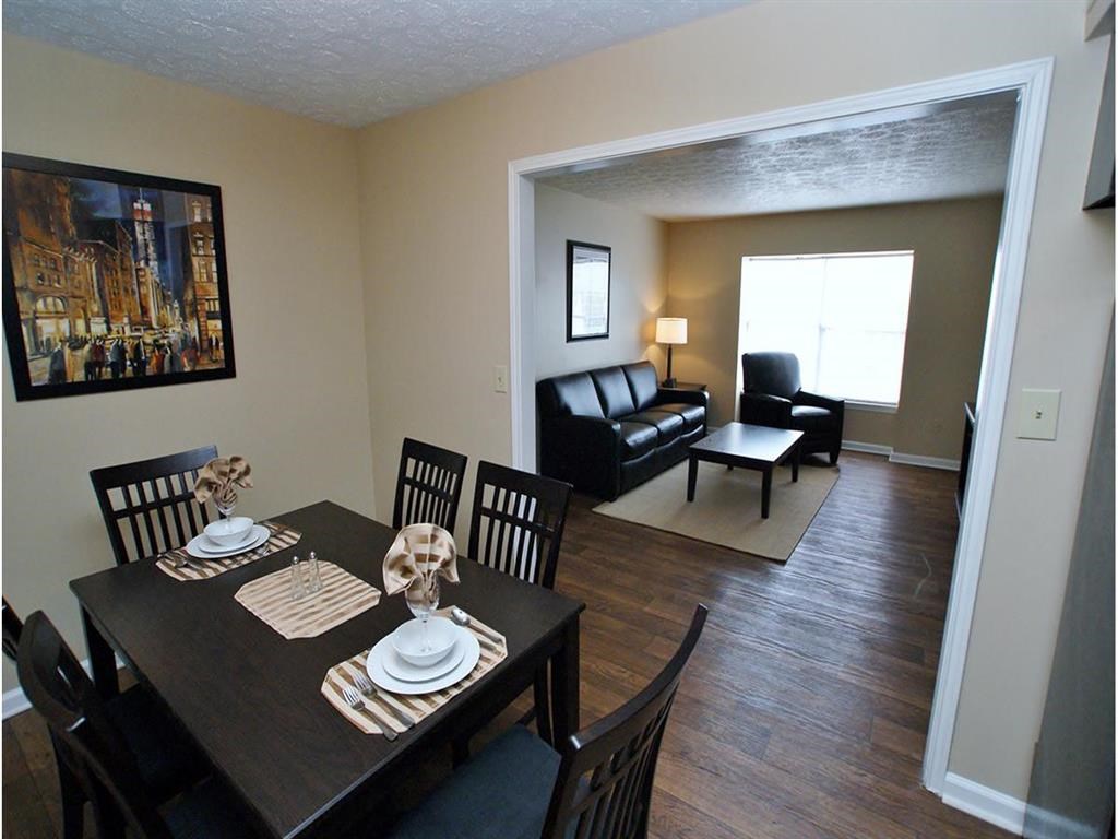 a dining room and living room with a table and chairs