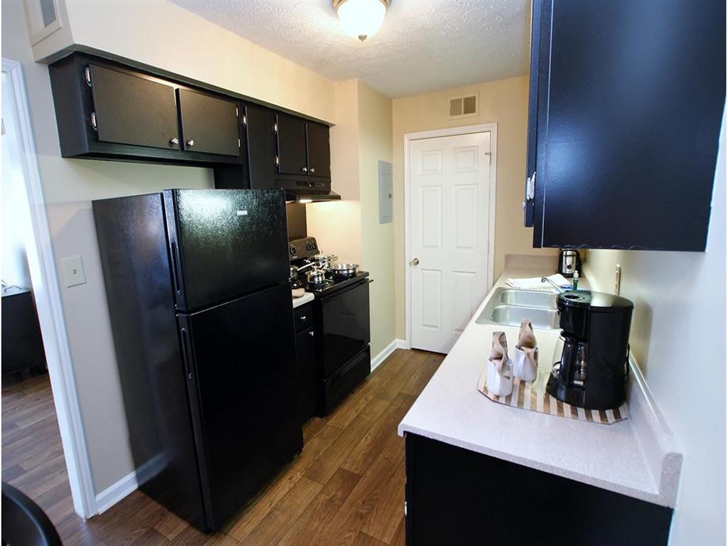 a kitchen with black cabinets and a black refrigerator
