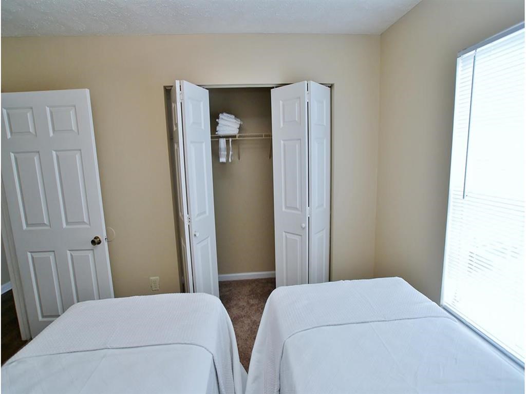 a bedroom with two beds and a closet with two doors