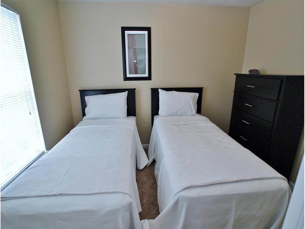 a small bedroom with two beds and a dresser