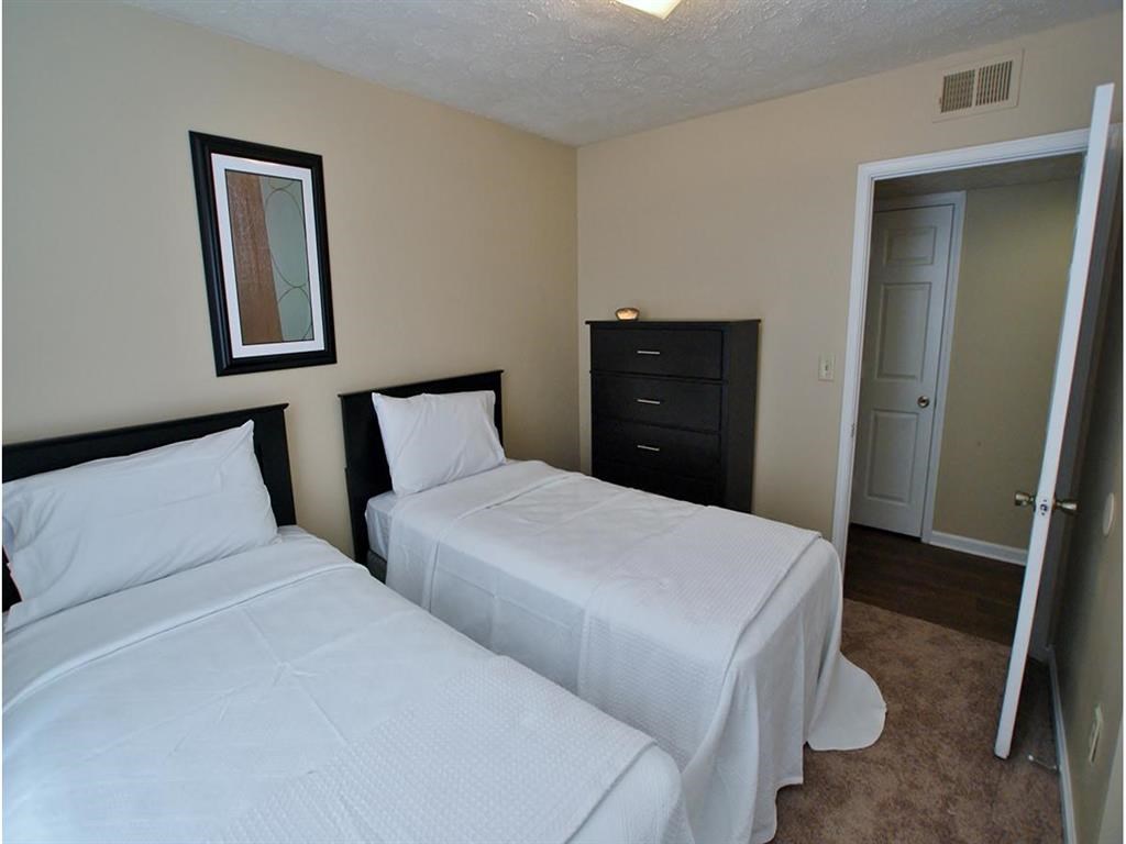 a bedroom with two beds and a mirror