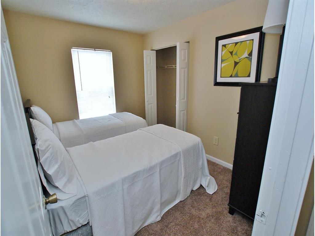 a bedroom with two beds and a mirror and a closet