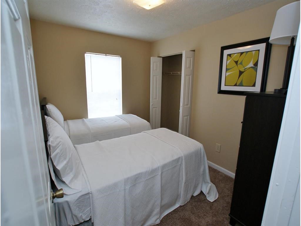 a bedroom with two beds and a door to a closet
