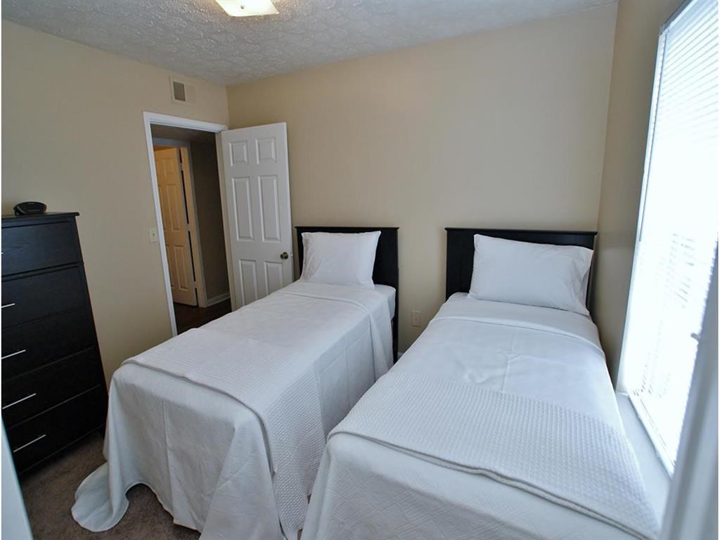 a bedroom with two beds and a door