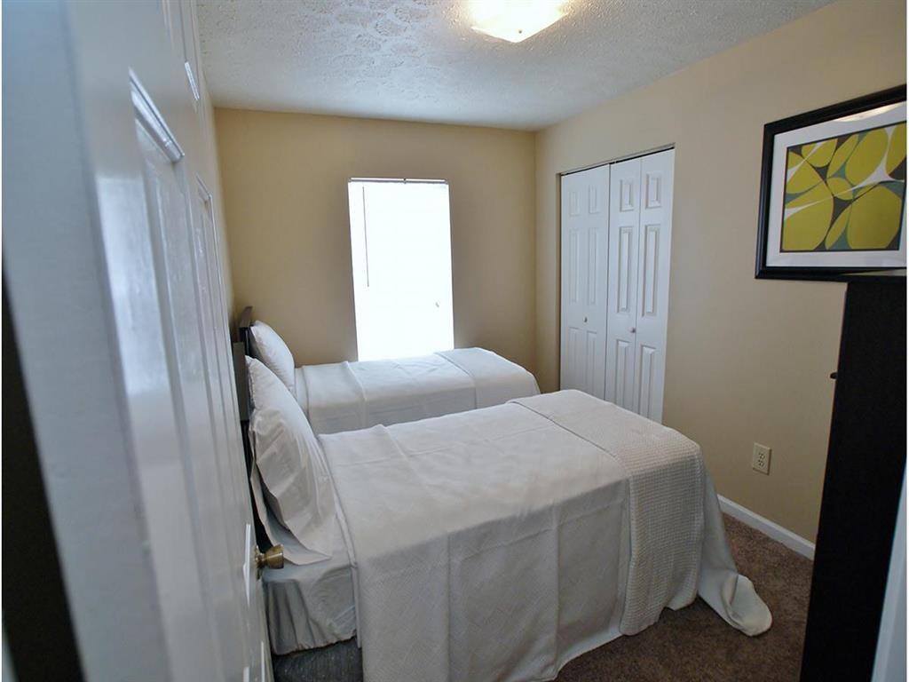a bedroom with two beds and a door to a closet