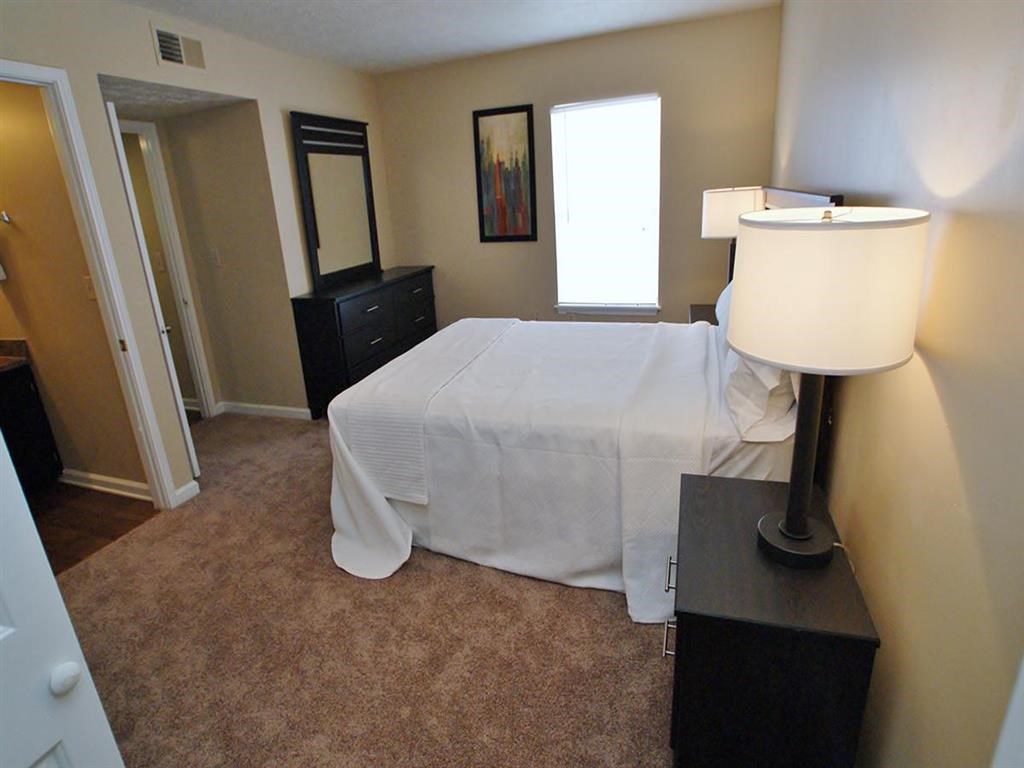 a bedroom with a white bed and a lamp