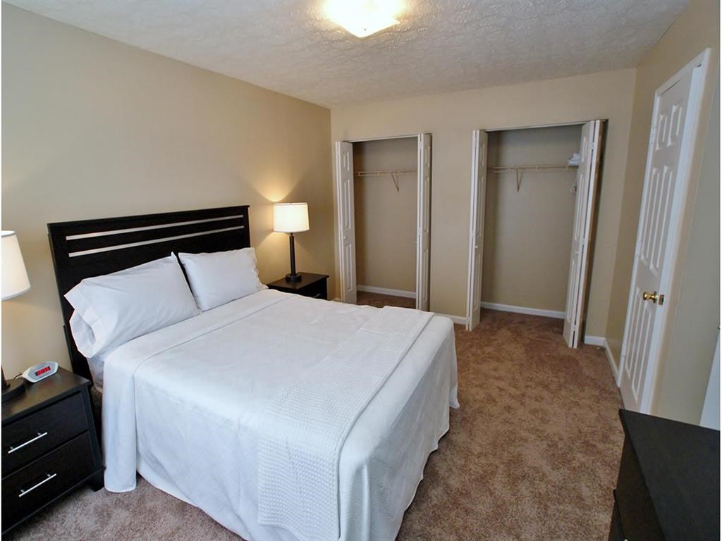 a bedroom with a white bed and a closet