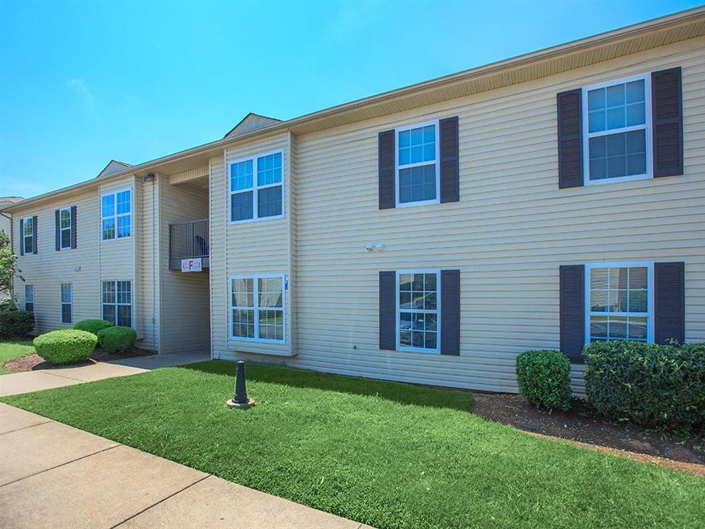 a white house with black shutters and a lawn
