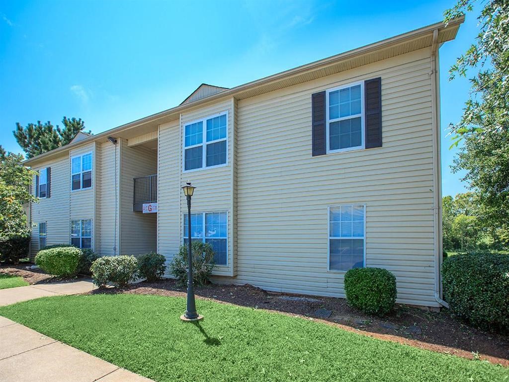 a tan house with a yard and a lamp post in front of it