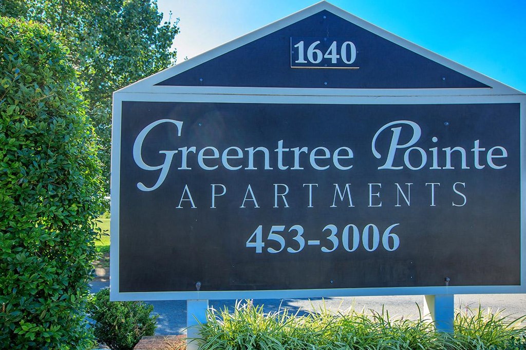 a sign for greentree point apartments in front of trees