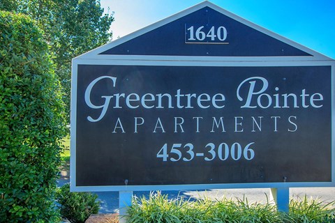 a sign for greentree point apartments in front of trees