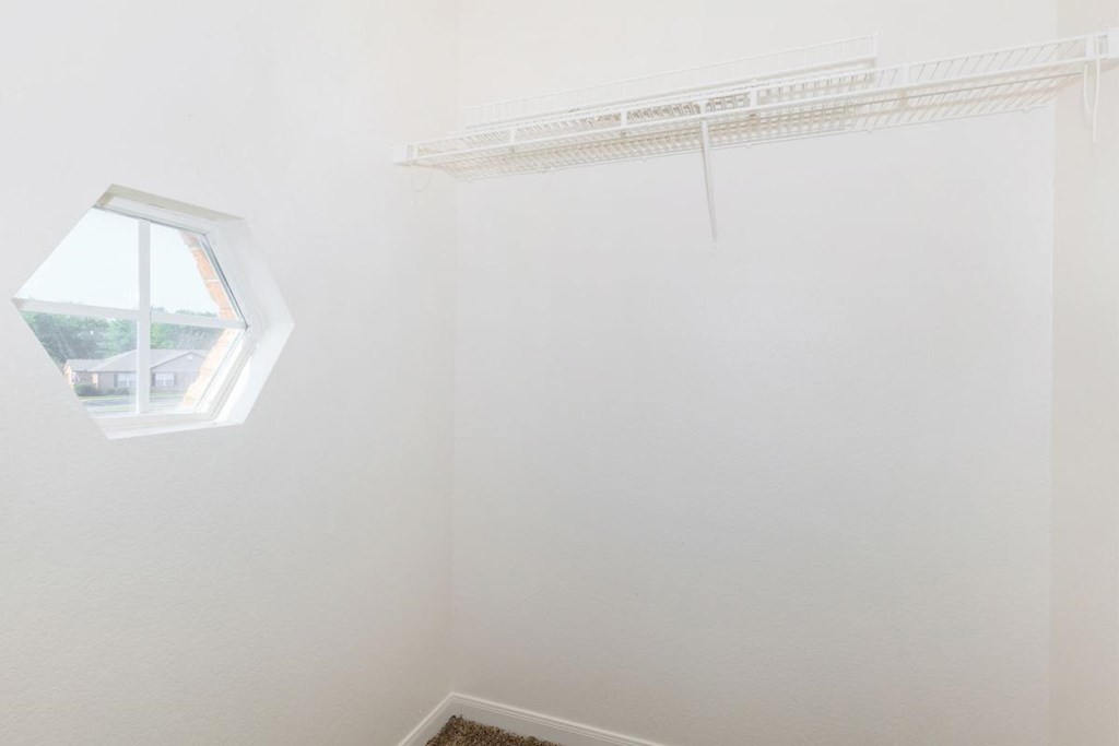 a small window in a white room with white walls