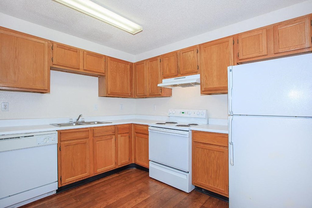 a kitchen with white appliances and wooden cabinets