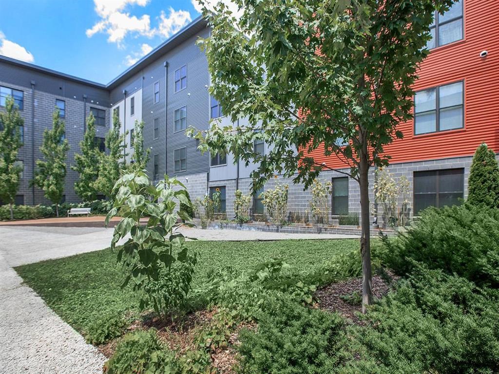 a courtyard with a tree in front of a building