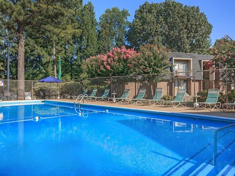 a large swimming pool with chairs around it