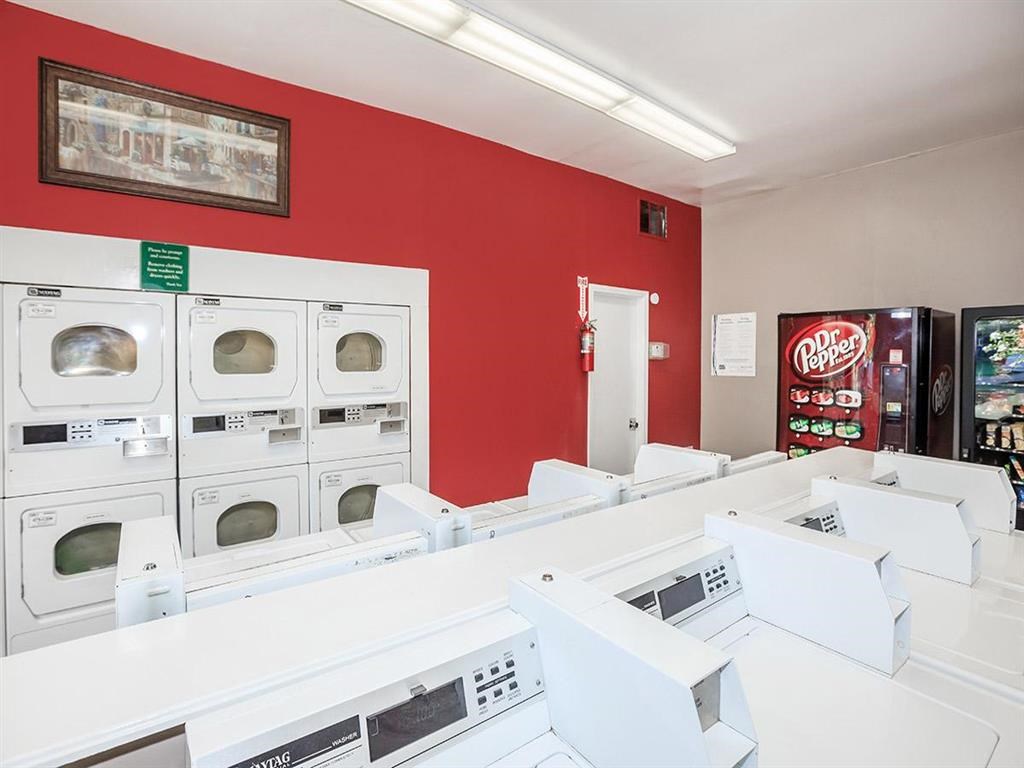 a laundromat with a bunch of white washing machines