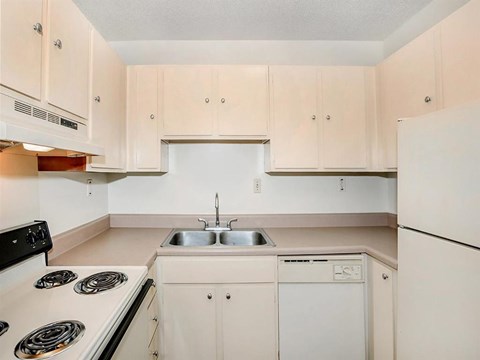 a white kitchen with white appliances and white cabinets