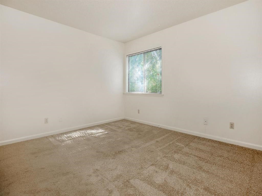 an empty room with carpet and a window