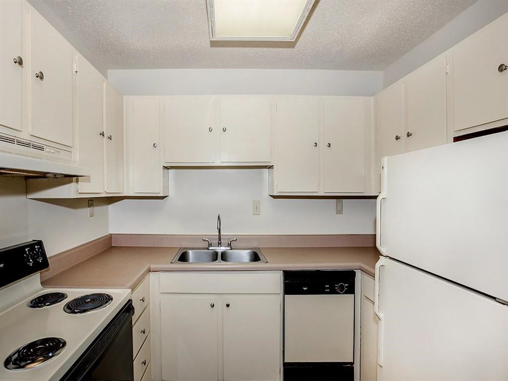 a kitchen with white cabinets and a stove and a refrigerator