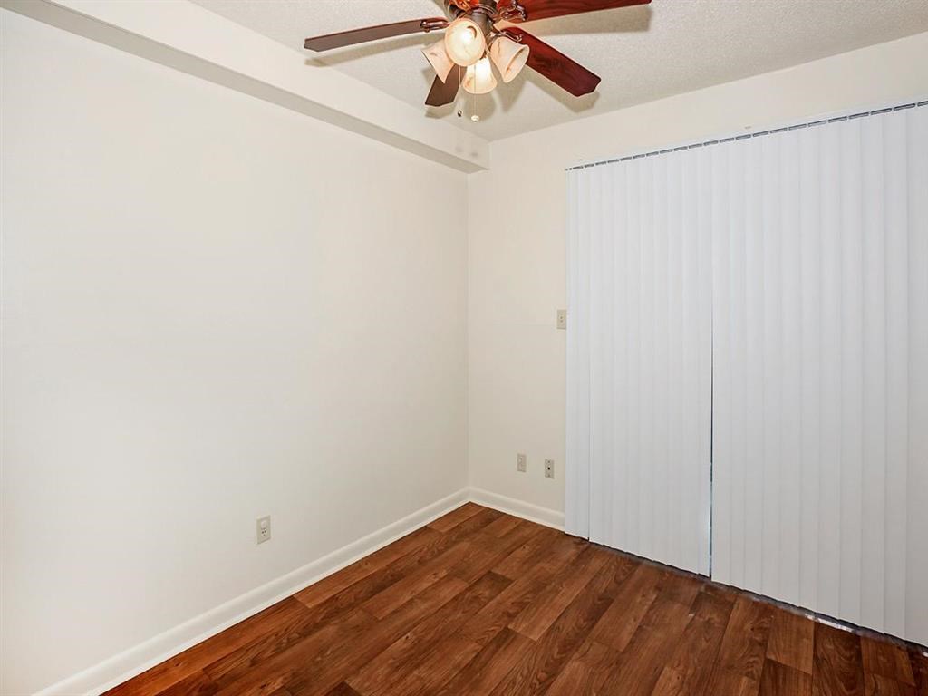 a bedroom with a ceiling fan and a closet